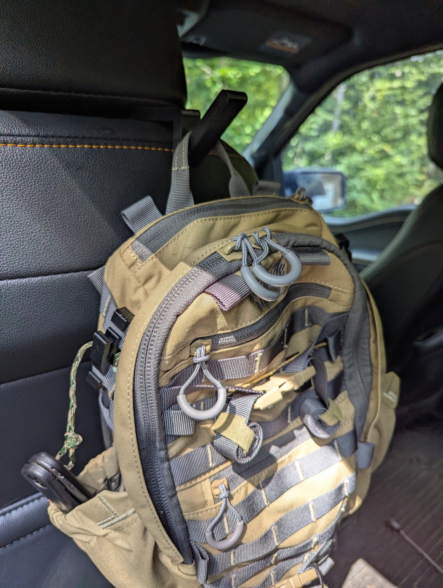 3D Hunting Solutions arrow accessory headrest post with bow and gear hanger mounted on vehicle headrest.