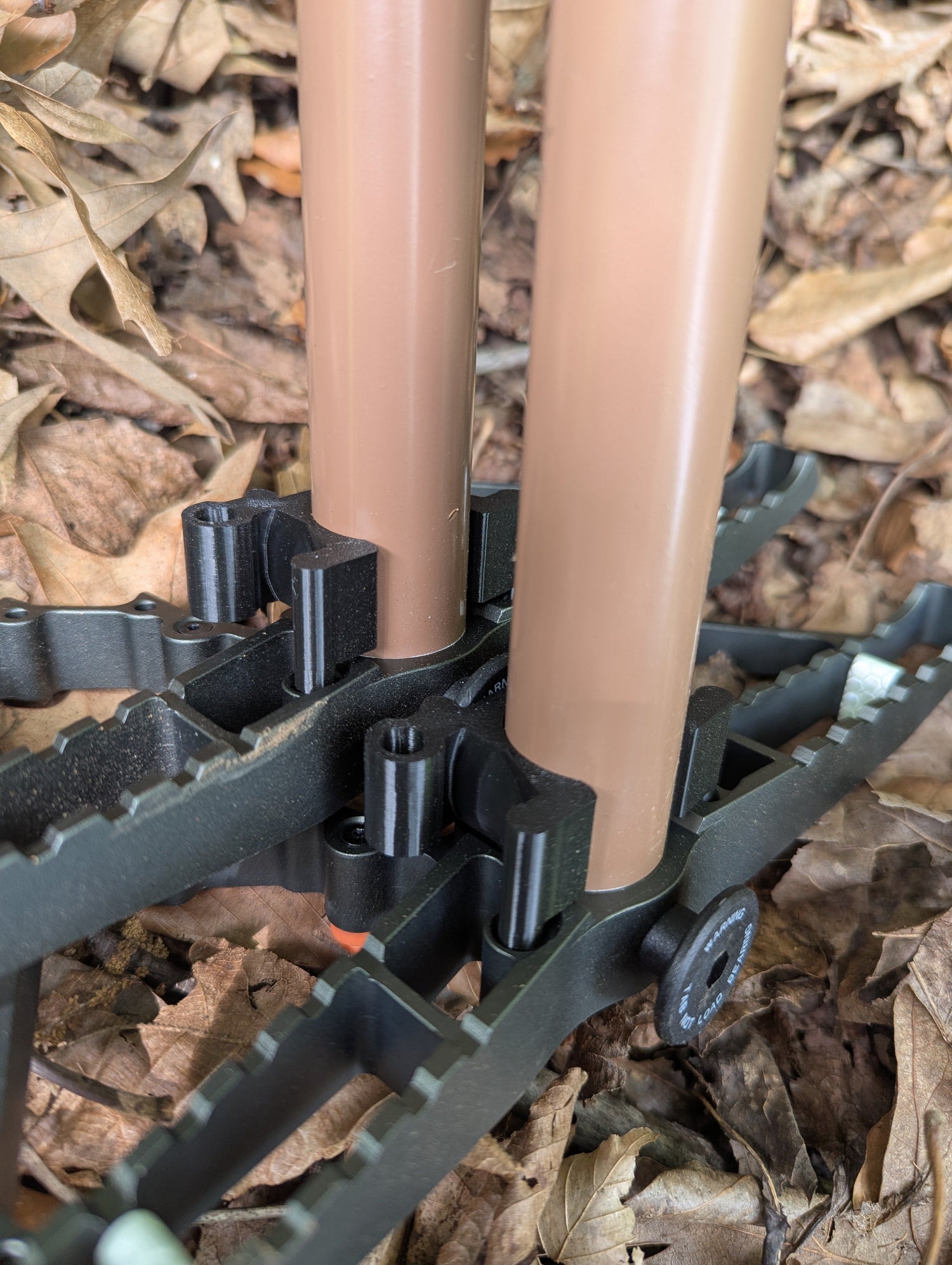 Three 3D Hunting Solutions Tethrd One Stick Wranglers climbing sticks stacked for use and storage, part of the climbing stick management system.