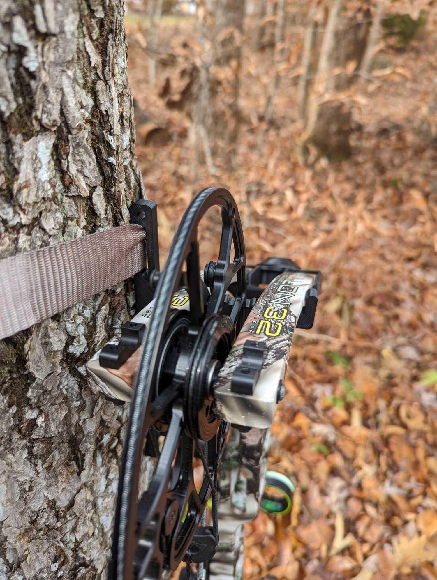 Amsteel strap bow hanger by 3D Hunting Solutions hanging from a tree for outdoor archery storage and organization.