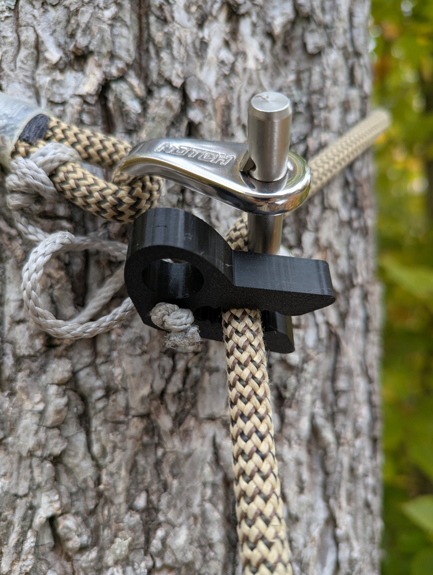3D Hunting Solutions T-Rex Tether Clip for mobile and saddle hunting, shown attached to hunting gear for secure support.