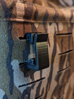 3D Hunting Solutions Molle hook hanger for tactical gear, shown attached to a molle webbing system in a close-up view.