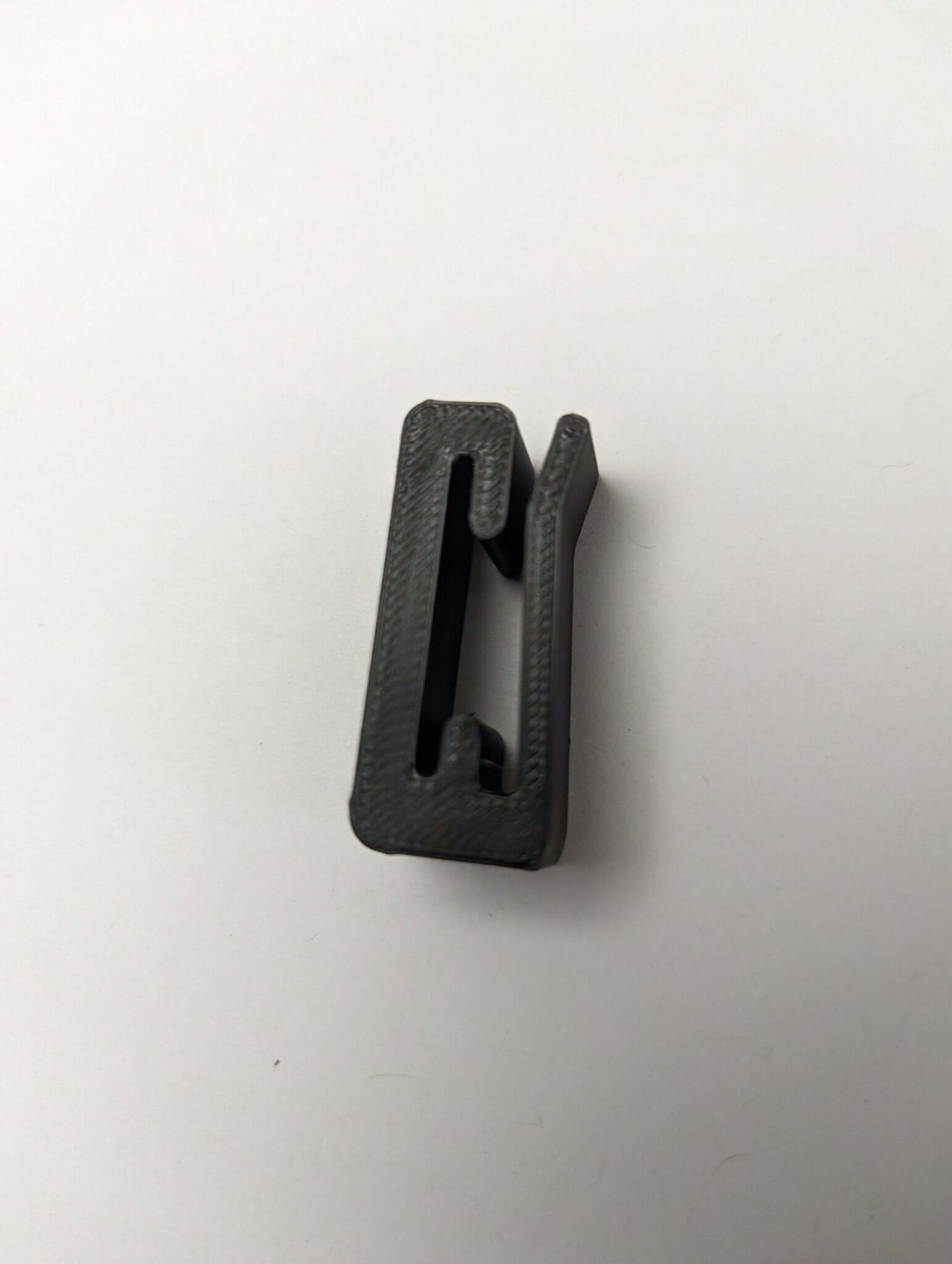 3D Hunting Solutions Molle Hook Hanger for tactical gear, sturdy metal hook attached to a MOLLE panel for secure gear storage.