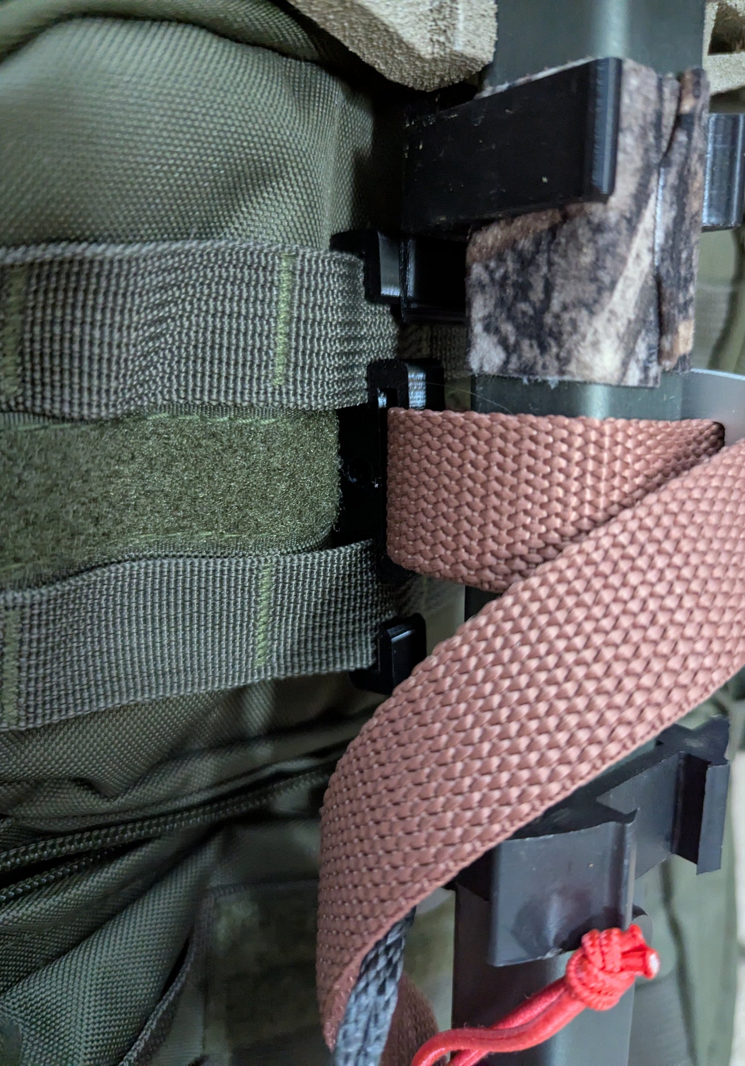 3D Hunting Solutions Molle Reverser Clip attached to climbing sticks for secure gear attachment and easy access during hunting.