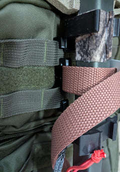 3D Hunting Solutions Molle Reverser Clip attached to climbing sticks for secure gear attachment and easy access during hunting.
