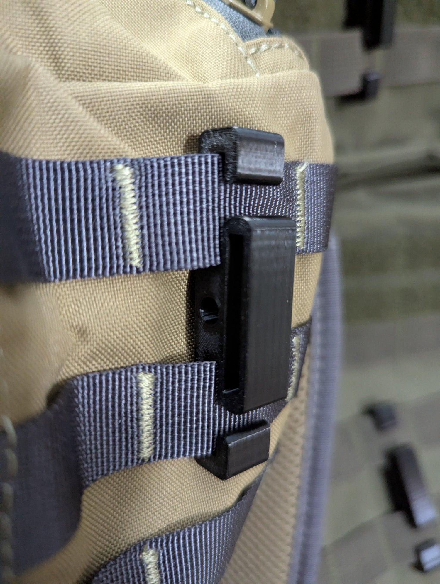 3D Hunting Solutions Molle Reverser Clip attached to climbing sticks, used for gear attachment and secure fastening.