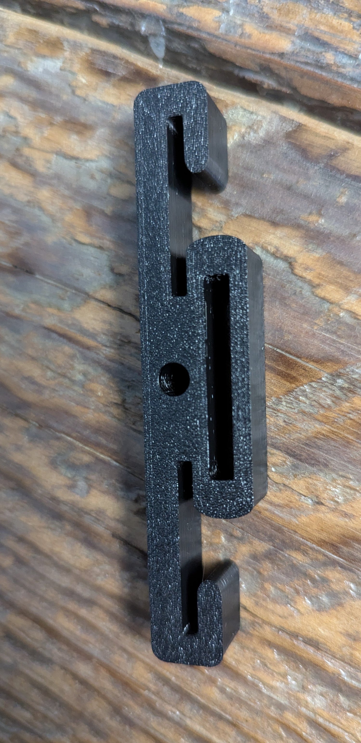 3D Hunting Solutions Molle Reverser Clip attached to climbing sticks, designed for secure gear attachment and climbing support.