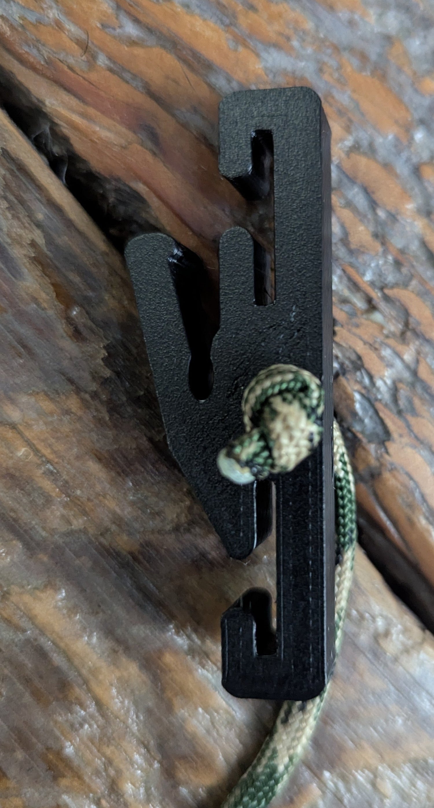 3D Hunting Solutions Molle Reverser Clip attached to climbing sticks for secure gear attachment in outdoor climbing and hunting setups.