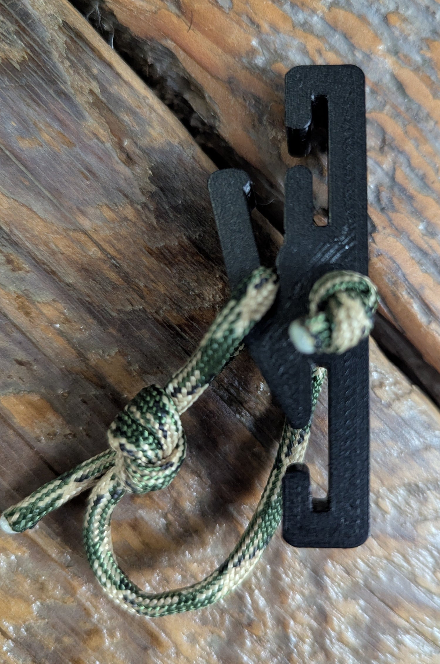 3D Hunting Solutions Molle Reverser Clip attached to climbing sticks for secure gear attachment in outdoor climbing and hunting setups.