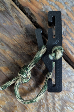 3D Hunting Solutions Molle Reverser Clip attached to climbing sticks for secure gear attachment in outdoor climbing and hunting setups.