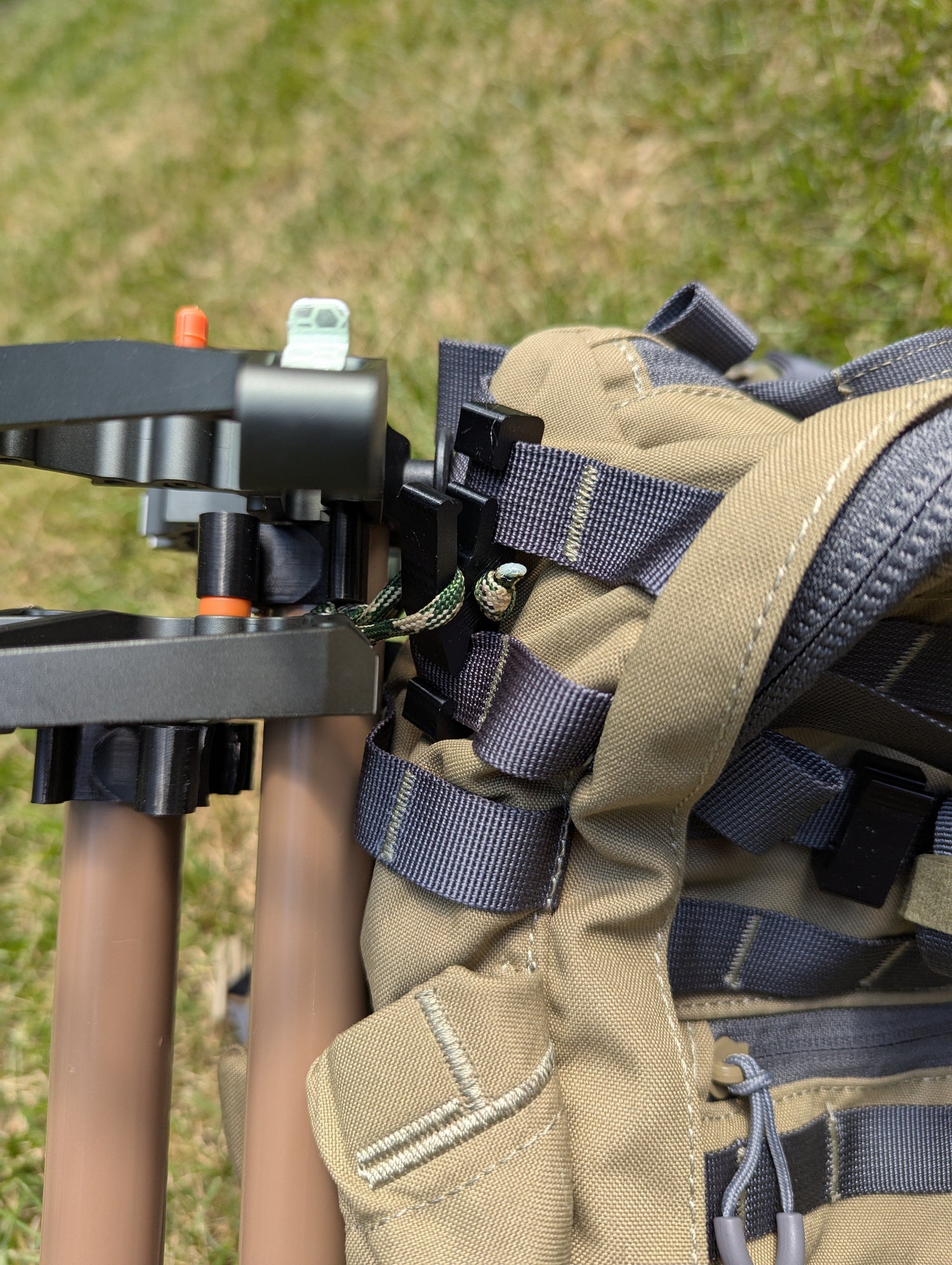 3D Hunting Solutions Molle Reverser Clip attached to climbing sticks, showing secure Molle loop for gear attachment.