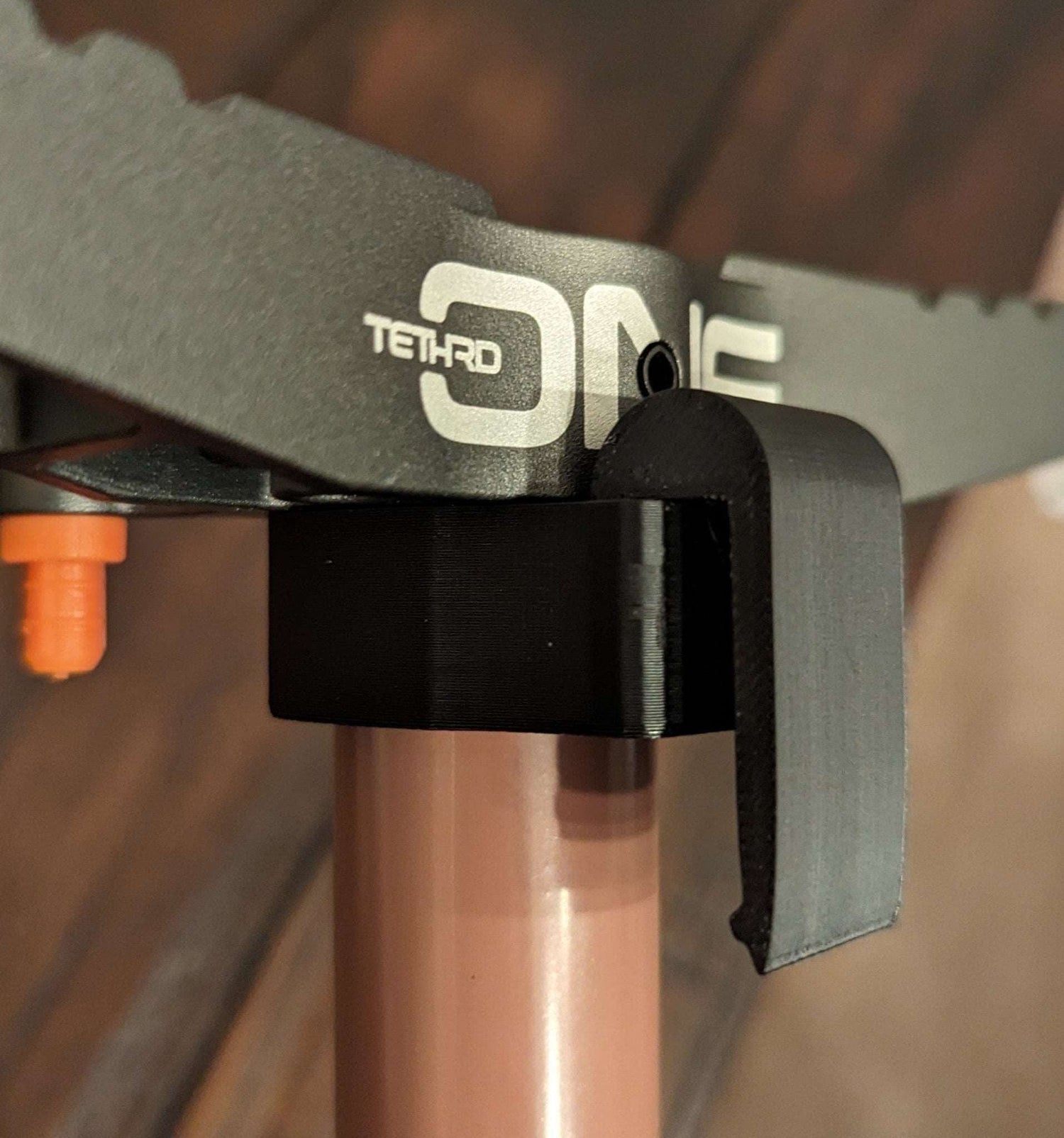 Tethrd One Stick Caddy for saddle hunting by 3D Hunting Solutions, showing the caddy attached to a saddle with climbing sticks.