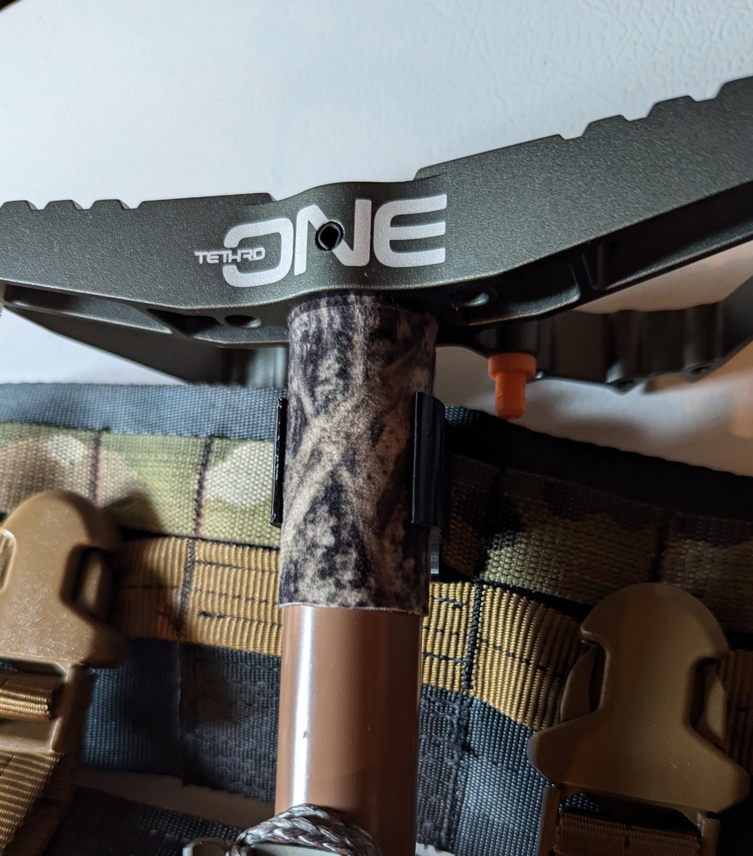 Vertical Tethrd One Molle Caddy for saddle hunting by 3D Hunting Solutions, attached to a saddle with gear slots visible.