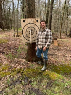Wooden axe throwing target with built-in bottle opener by BIGshot Archery, featuring a rustic design and axe target zones.