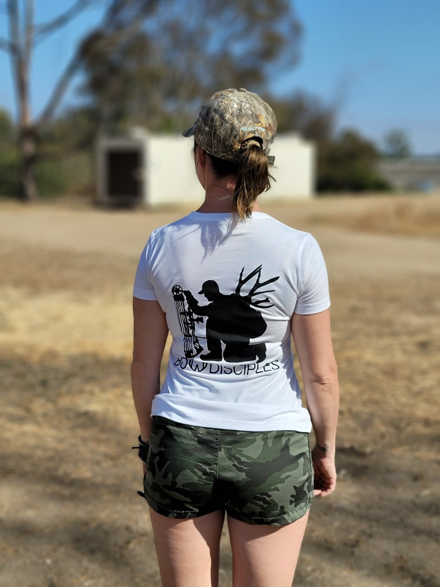 White Houdini Ladies Tee by Bow Disciples, featuring a casual fit with the brand logo on the front, displayed on a hanger.