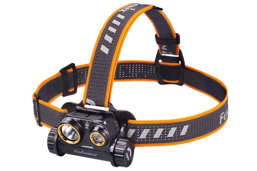 Fenix HM65R rechargeable LED headlamp with 1400 lumens, worn on a user's head, showing adjustable straps and bright light in a dark setting