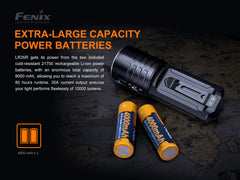 Fenix LR35R rechargeable LED flashlight with a black body and large lens, emitting bright light for outdoor or tactical use.