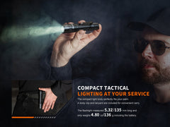 Fenix PD32R rechargeable tactical flashlight with silent switch, black body, compact design, and LED light on a dark background.