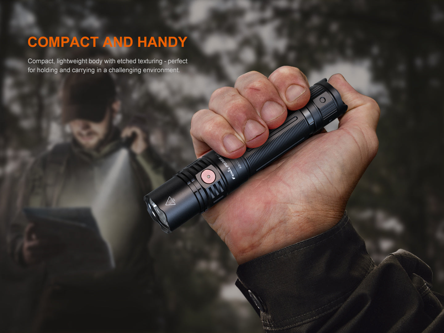 Fenix PD36R V2 compact rechargeable tactical flashlight emitting bright light, black body with textured grip, on a dark background.