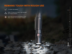 Fenix PD36R V2 compact rechargeable tactical flashlight emitting bright 1700 lumens, with a rugged black body and adjustable focus.